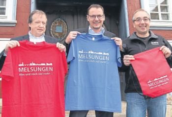 Eine bunte neue Idee: Friedrich Riemann, Bürgermeister Markus Boucsein und Hans-Werner Horn mit den neuen T-Shirts und Taschen mit der Melsunger Silhouette. Sie sind ab der kommenden Woche erhältlich. Foto: Brandau