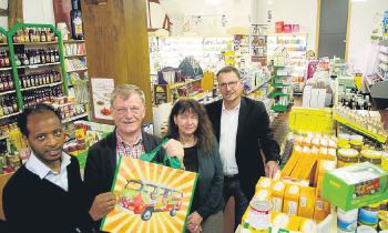Schicke Tüte: Filmon Haile und Johannes Iffland vom Reformhaus zeigen die haltbare Einkaufstüte. Karin Plötz-Hesse und Bürgermeister Markus Boucsein gaben im Reformhaus das Ergebnis der Haussammlung bekannt. Foto: Dewert