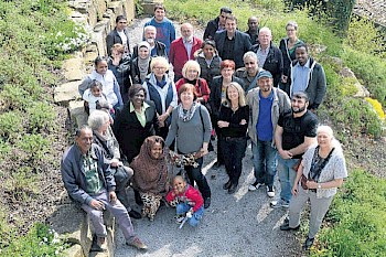 Gemeinsam Deutsch lernen: Flüchtlinge und ihre ehrenamtlichen Lehrer im Hinterhof von Harnings Mühle in Melsungen. Foto: Pflug