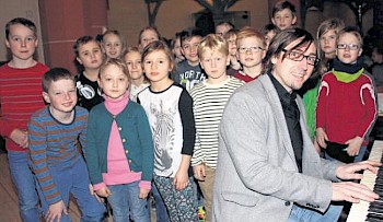 Ihr Musikinstrument ist die eigene Stimme: Grundschüler in der Stadtkirche mit Primacanta-Projektleiter Sebastian Schilling. Foto: Grugel