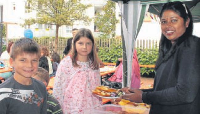 Weltkindertag am Lutherhaus: Laurin (9, von links) und Malina (11) holen sich Süßes und Salziges bei Sunita Schröder. Foto: Thiele